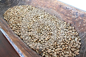 Green coffee beans in wooden bowl