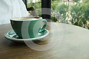 Green coffee cup on a wooden table