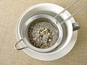 Green coffee in tea strainer