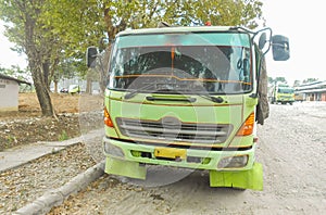 Green colored flatbed heavy trucks used to transport and distribute cements sacks from factory to points of sales or distributors