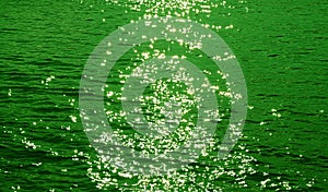 Green colored sparkling water surface with sea ripples