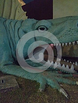 A green colour dinosaur cave in a theme park of kolkata