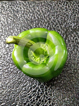 Green coloured female bell pepper. Female bell peppers have four lobes or bumps and sweeter in taste