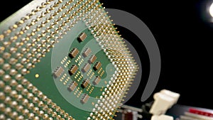 Green computer CPU microprocessor or processor on a black background. Close up of metallic gold pins of computer