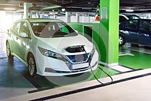 Green concept car. Hybrid vehicle - green technology of future. Electric car charge battery on eco energy charger station. Eco-