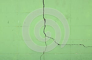 green concrete block wall with large cracked