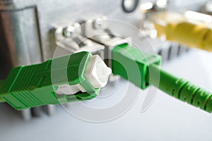 Green connector optical patch cord on the background of the optical receiver to broadcast the TV