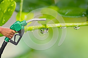 Green conservation. Gas pump nozzle and leaf background. Fuel dispenser on nature background.