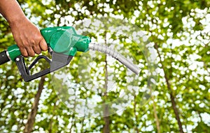 Green conservation. Gas pump nozzle and leaf background. Fuel dispenser on nature background.