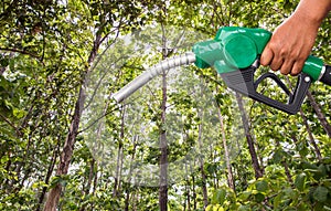 Green conservation. Gas pump nozzle and leaf background. Fuel dispenser on nature background.