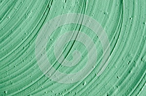 Green cosmetic clay facial mask, cream, body scrub texture close up, selective focus. Abstract background