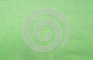 Green cotton material with visible texture. macro photo