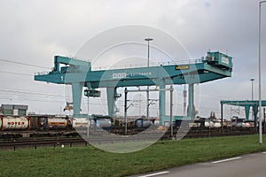 Green cranes of the RSC container terminal for loading on trains in the waalhaven harbor in the port of Rotterdam.