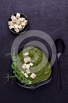 Green cream soup with slices of cheese