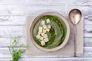 Green cream soup with slices of cheese