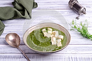 Green cream soup with slices of cheese