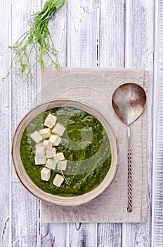 Green cream soup with slices of cheese