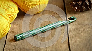 Green Crochet Hook with Yellow Yarn and Pinecone