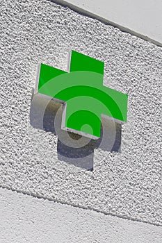 Green cross logo of Pharmacy sign in street