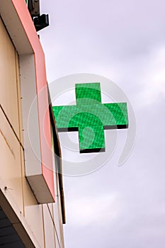 Green cross pharmacy sign on a building