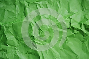 Green crumpled paper texture background.