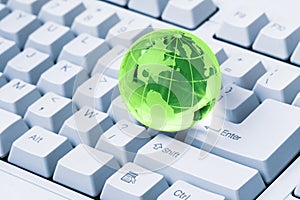 Green crystal globe of the Earth on a computer keyboard
