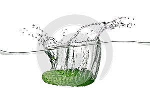 Green cucumber dropped into water photo