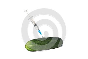 A green cucumber was pricked with a syringe on a white isolated background.