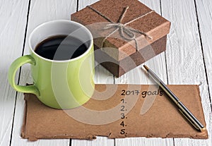 Green cup of coffee,brown gift box ,pen and old paper note