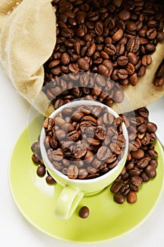 Green cup and saucer with coffee crop