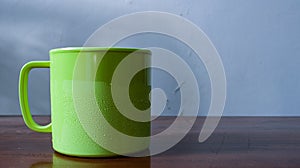 Green cup on a wooden table