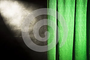 Green curtain against a black background with the top reflector light