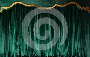 Green curtain of luxurious velvet on the theater stage. Copy space. The concept of music and theatrical art.