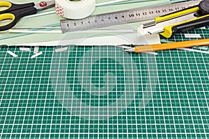 Green cutting mat with various school tools and office supplies