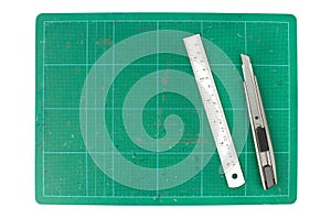 Green cutting mats with iron ruler and cuter on white background