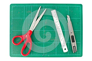 Green cutting mats with scissors ruler and cuter on white background