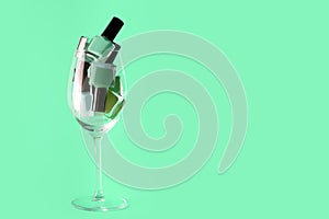 Green, cyan nail polish bottles set. Nail polish bottles in wine glass. Green nail polsih bottles on cyan background