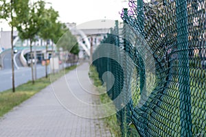 Green damaged wire-mesh fence is ruined after collision with car accident as crushed fence car insurance and property insurance