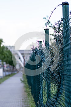 Green damaged wire-mesh fence is ruined after collision with car accident as crushed fence car insurance and property insurance