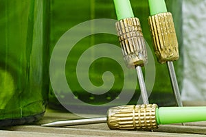 Green darts from a dartboard resting on beer bottles