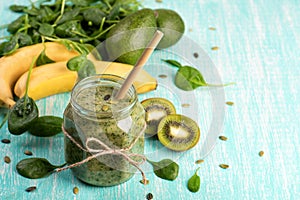 Green detox smoothie in a glass jar with banana, kiwi, spinach