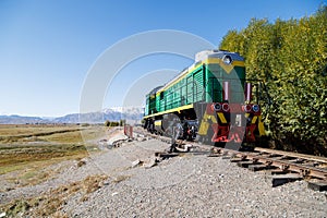green diesel locomotive crossing small bridge at summer day in Balykchy, Kyrgyzstan
