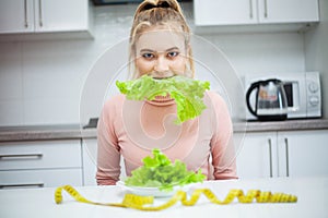 Green diet. Young beautiful woman eating healthy food - salad