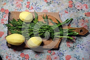 Green dill and peeled uncooked potatoes