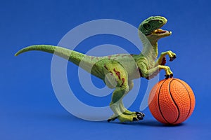 Green dinosaur toy with basketball ball. Basketball minimal card blue background