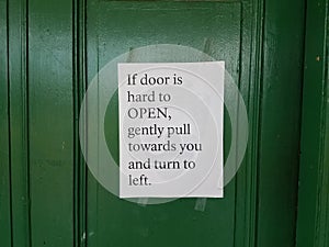 Green door with instructions how to open