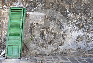 Green door leaning against wall.