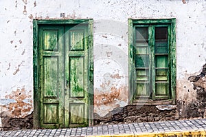 Green door and window of an old house in Spain