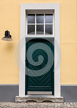 A green door on a yellow building in a German village