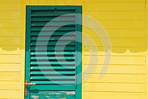 Green door on yellow wooden wall